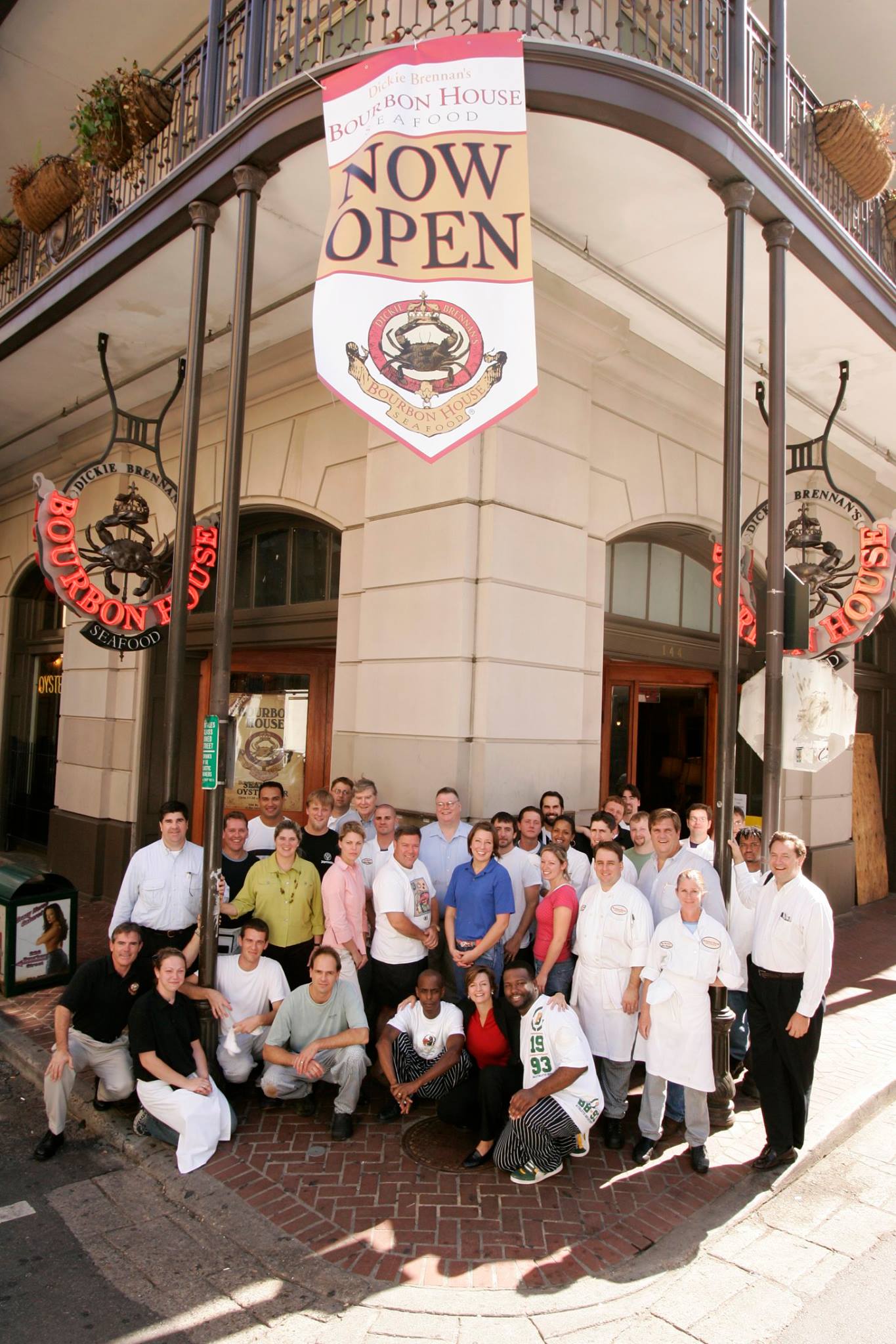 Staff of Bourbon House posing for a group photo in front of the restaurant.