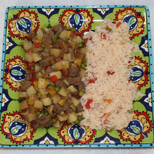 A beautifully plated dish of Bolivian Saice served with white rice