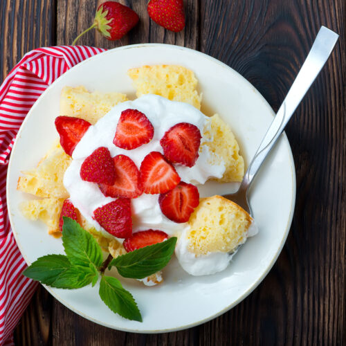 Plate of Strawberry Bliss Shortcake with whipped cream and fresh strawberries.
