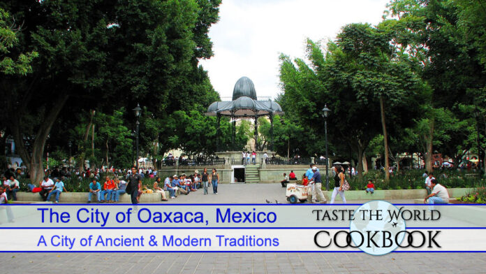 The bandstand and surrounding gardens in the Zócalo of Oaxaca, Mexico, with people relaxing on benches and walking around.